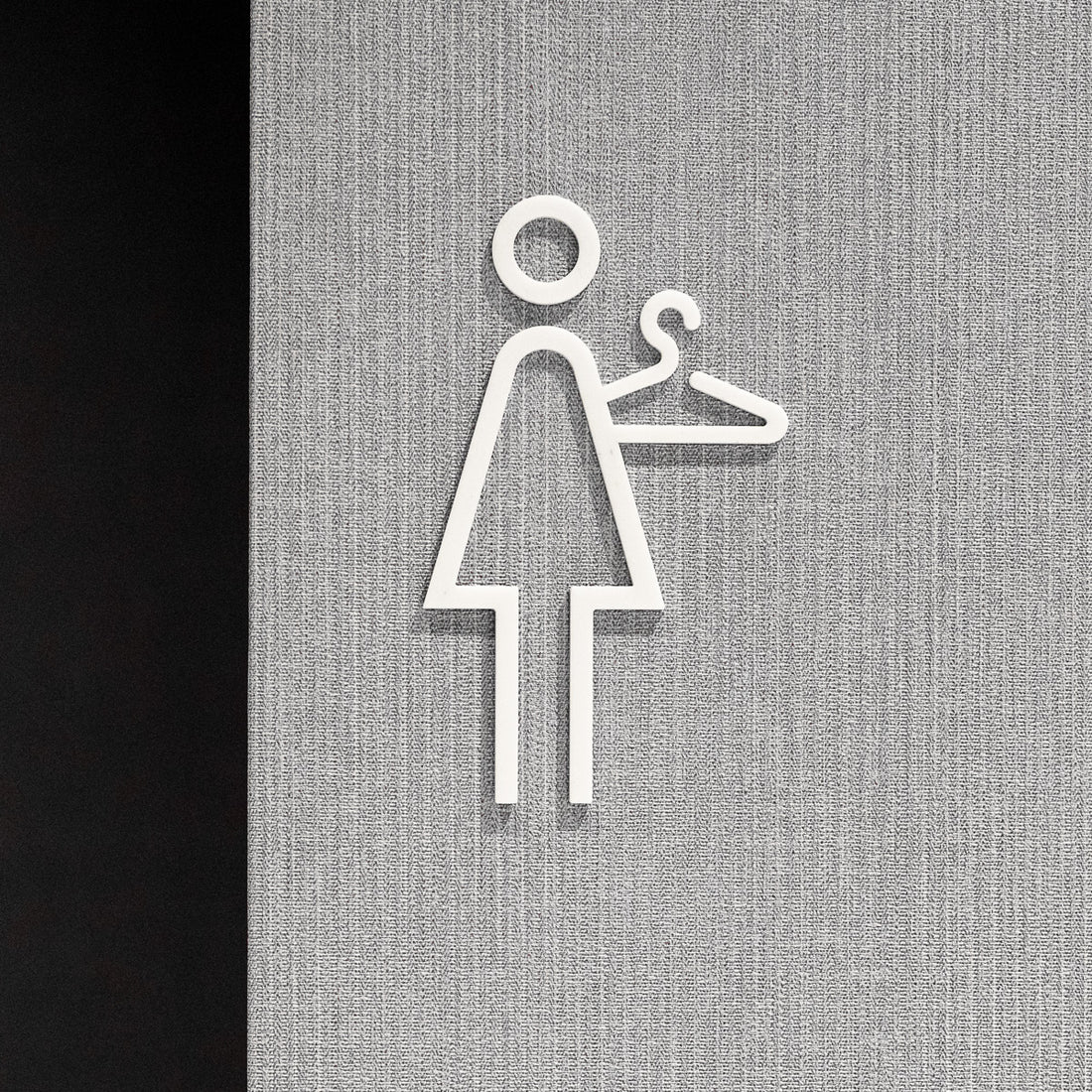 Pictogramme Vestiaire femme blanc, vue rapprochée